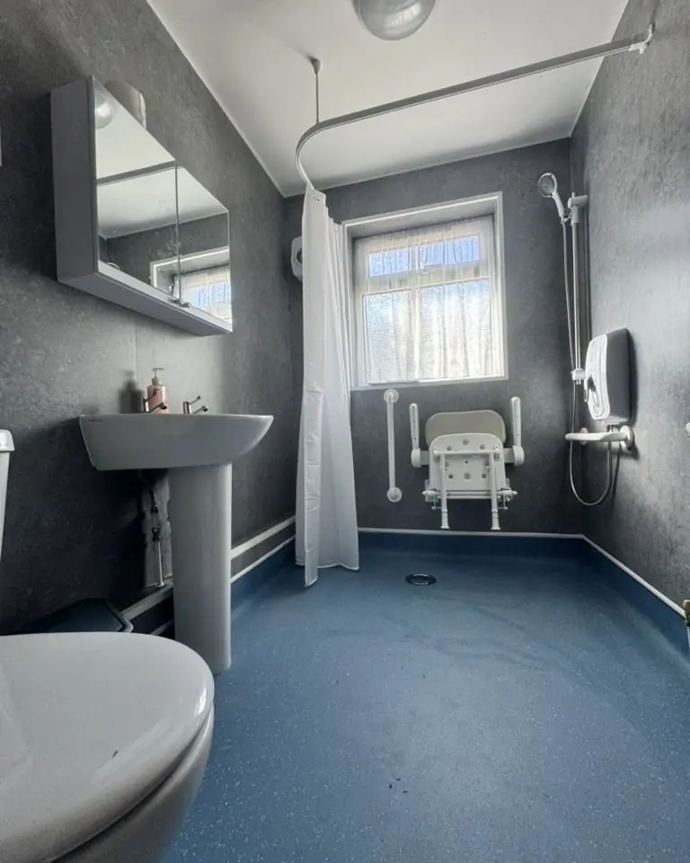 Accessible wet room with level-access floor, shower seat and grab rails