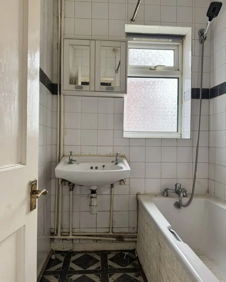 Old bathroom with bath and pedestal basin before adaptation