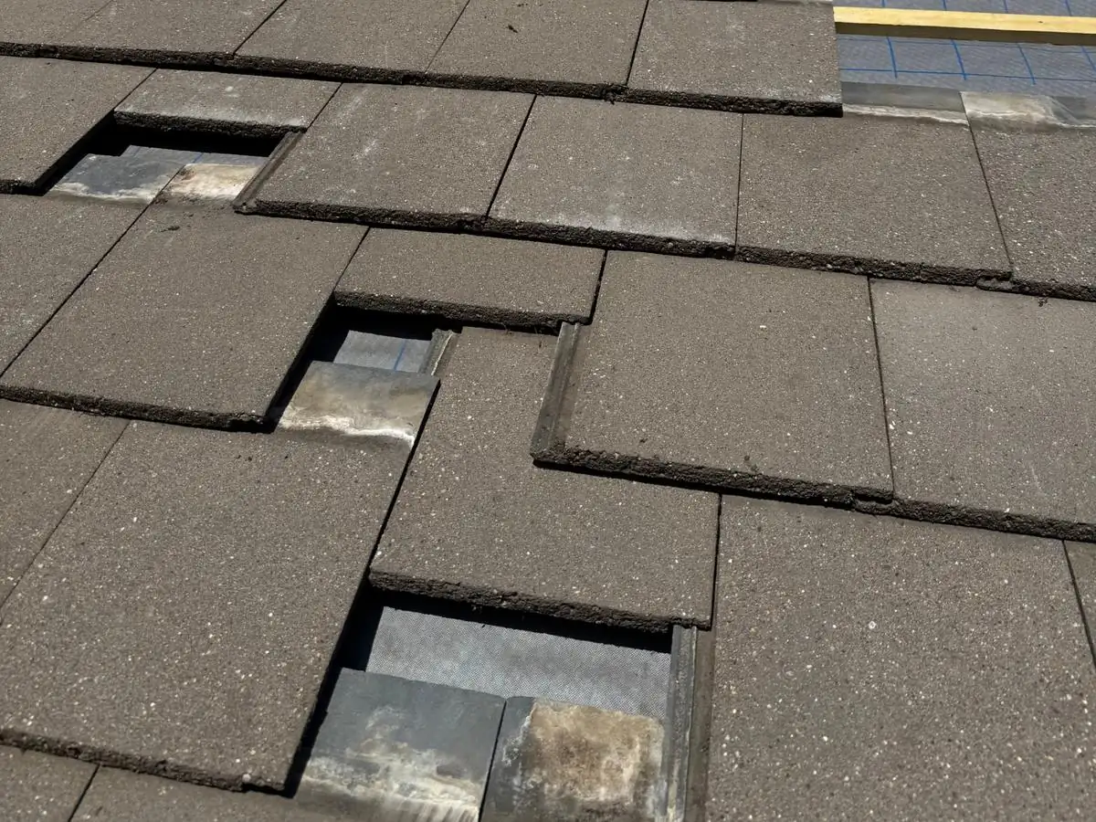 Roof with broken and missing concrete tiles exposing the underlay, the kind of damage the free Weekend Roof Clinic helps with