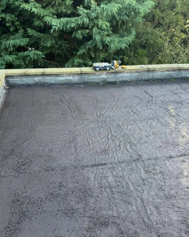 Same parapet flat roof cleared of moss, showing the worn old covering