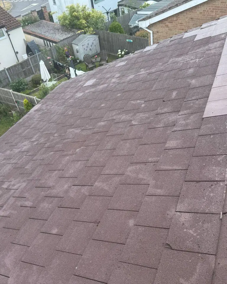 Repaired tiled roof with replacement tiles and a mechanically fixed ridge